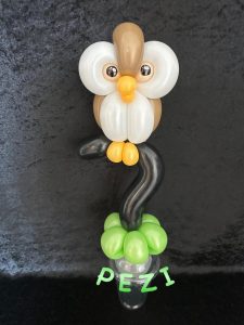 Braune Eule mit Luftballons geknotet